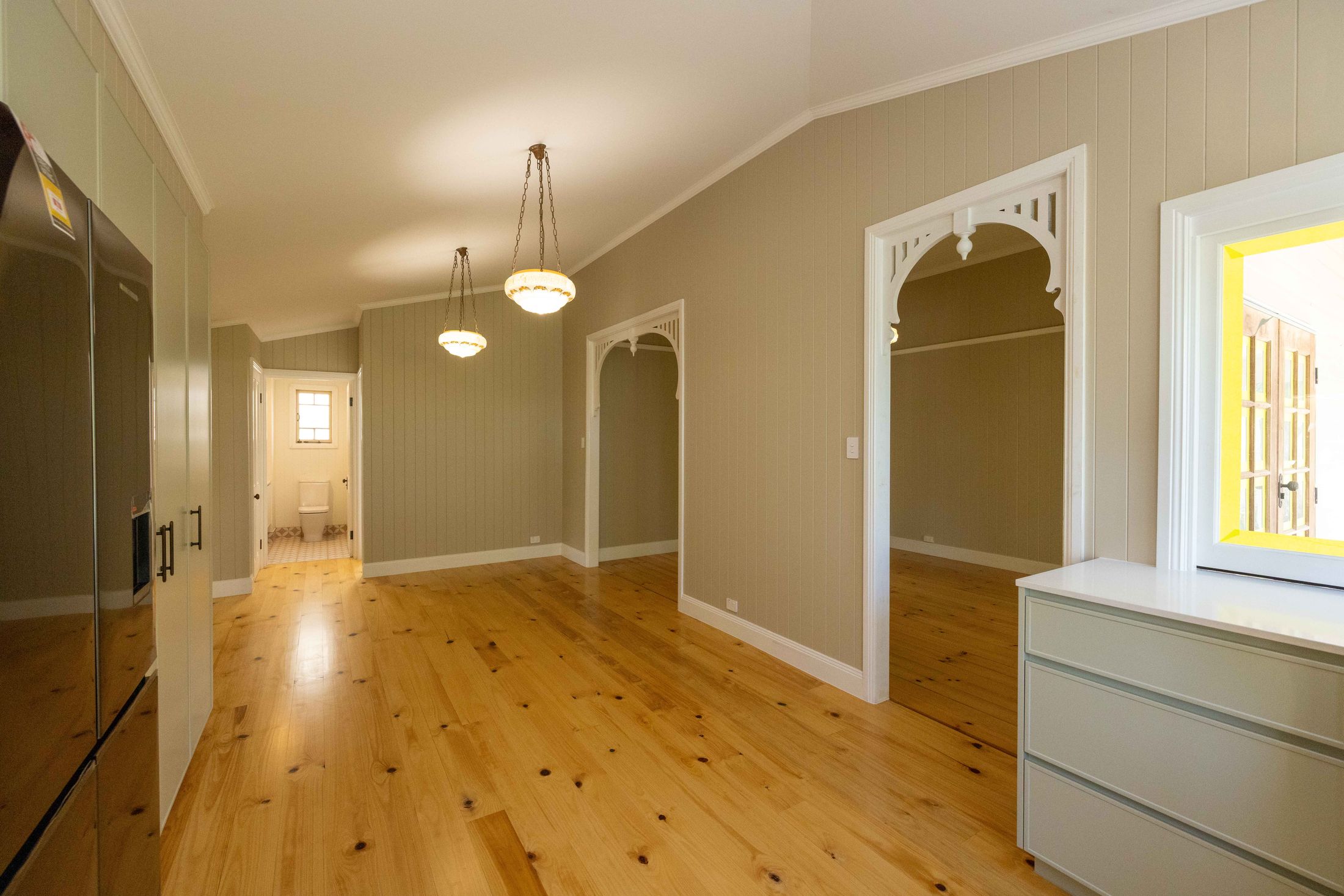 Restored Queenslander hallway with timber fretwork arches
