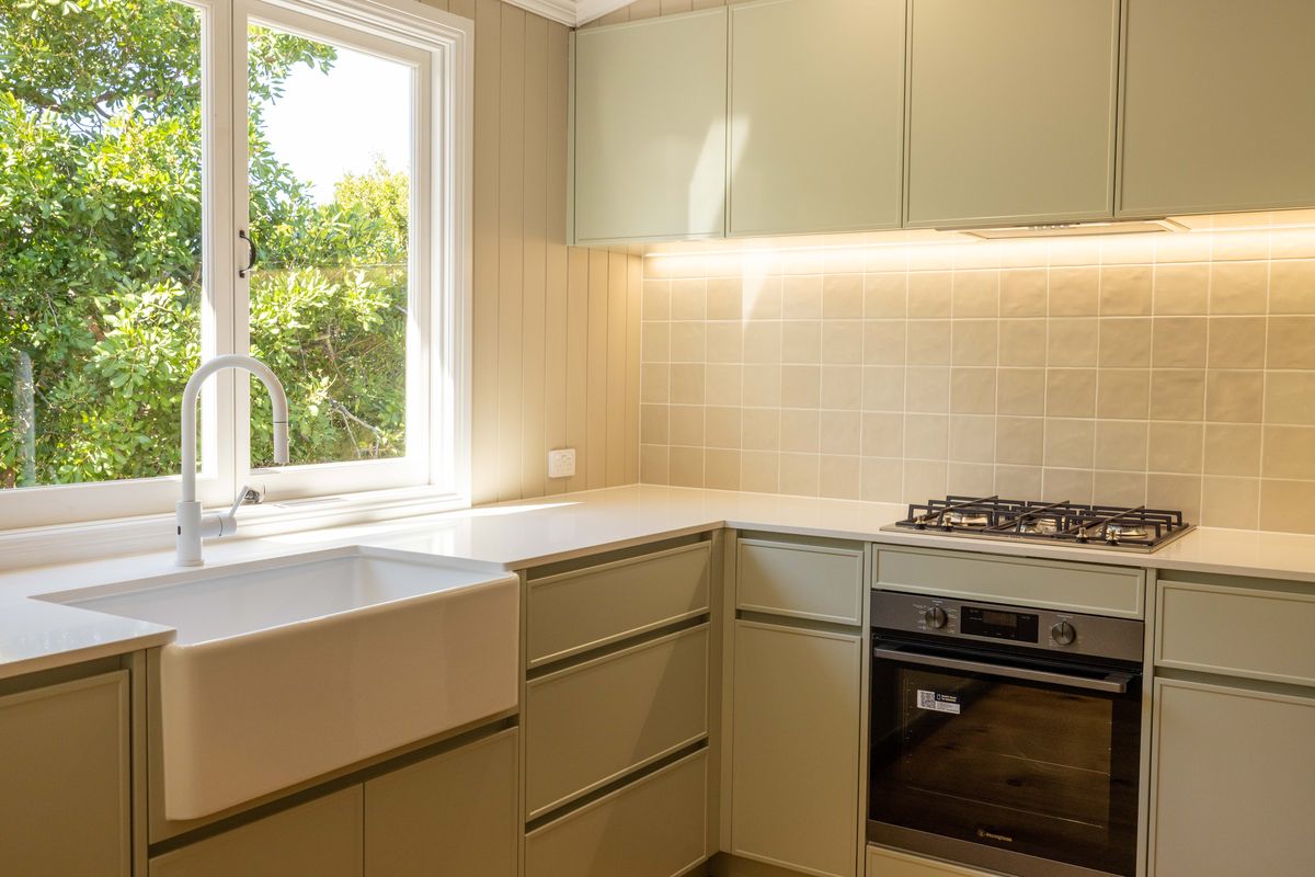 Kitchen with farmhouse sink and sage cabinetry in Balmoral