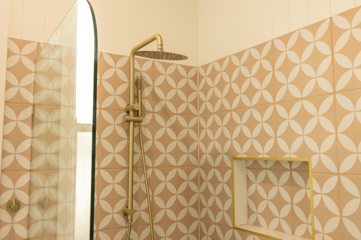 Renovated shower with patterned tiles and brass tapware