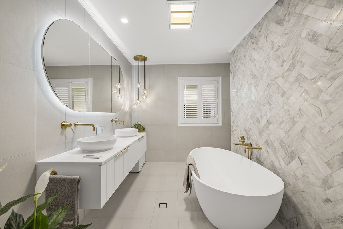 Bathroom with herringbone marble tiles and freestanding bath